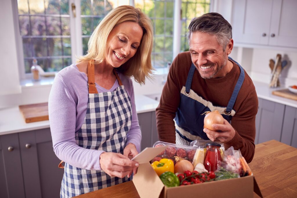 mature couple unpacking online meal food recipe kit delivered to home